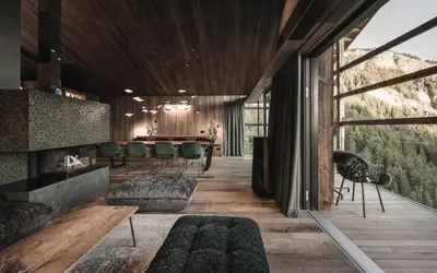 a living room with a fireplace and a table at Luxury Chalet Vilaiet in Ortisei