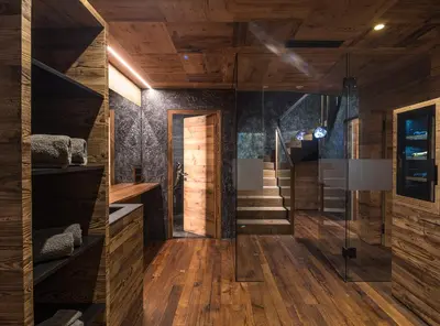 a room with wooden walls and a staircase with wooden floors at Luxury Chalet Vilaiet in Ortisei