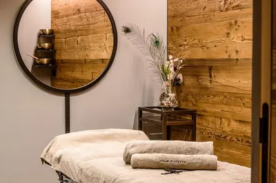 a room with a mirror and a table with a stool at Luxury Chalet Vilaiet in Ortisei