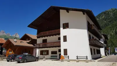 a large white building with a brown roof at Fraines in Alba di Canazei