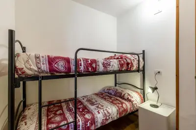 two bunk beds in a room with a table at Fraines in Alba di Canazei