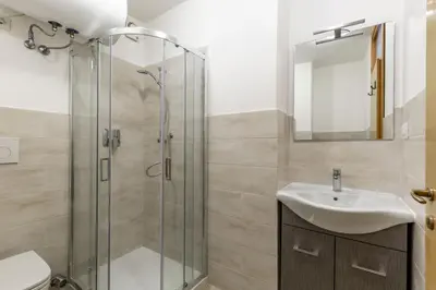 a bathroom with a glass shower and a sink at Fraines in Alba di Canazei