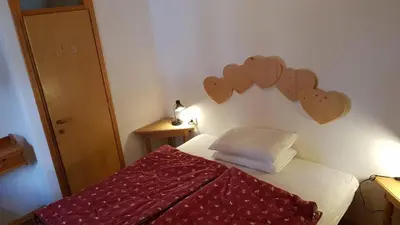 a bedroom with a bed with hearts on the wall at Fraines in Alba di Canazei