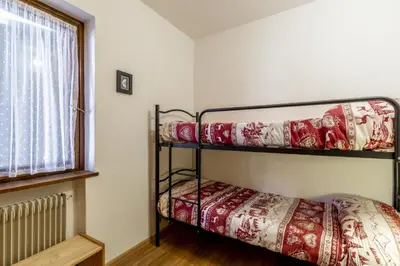 two bunk beds in a room with a window at Fraines in Alba di Canazei