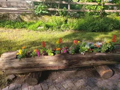 a wooden bench with a flower planter on it at APPARTAMENTO CORTINA 1956 in Cortina dʼAmpezzo
