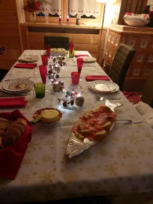 a table with a pizza and christmas decorations on it at APPARTAMENTO CORTINA 1956 in Cortina dʼAmpezzo