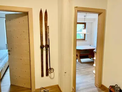 a room with a door and a bedroom with a desk at Appartements ai Sanc in Corvara in Badia