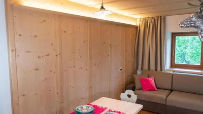a living room with a couch and a window at Appartements ai Sanc in Corvara in Badia