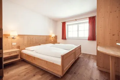 a bedroom with a large bed and a window at Hotel Rose Wenzer in Vols am Schlern