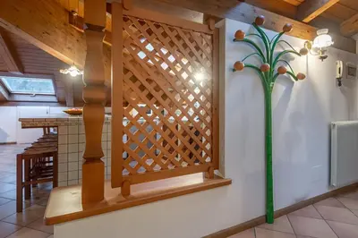 a wooden screen in a kitchen with a plant on the wall at DolomiApartments - Casa Margherita in Predazzo