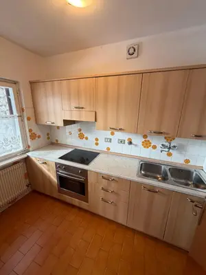 a kitchen with wooden cabinets and a sink at Appartamento Scacciapensieri in Meida