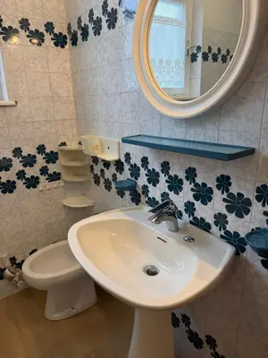 a bathroom with a sink and a mirror and a toilet at Appartamento Scacciapensieri in Meida