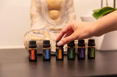 a hand reaches for a group of four bottles of essential oils at Wellness Smart Suites in Bolzano