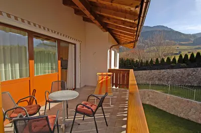 a patio with a table and chairs and a balcony at Haus Ploner in Castelrotto