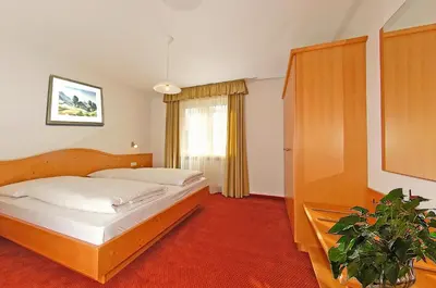 a bedroom with two beds and a potted plant at Haus Ploner in Castelrotto
