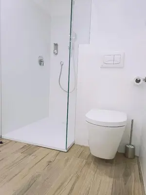 a white bathroom with a toilet and a shower at Apartment Teatro in Bolzano