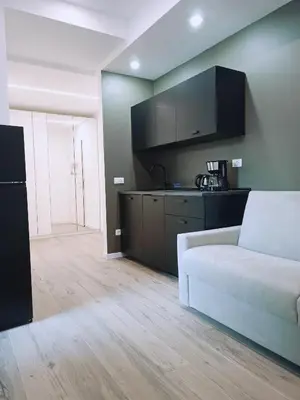 a living room with a white couch and a kitchen at Apartment Teatro in Bolzano