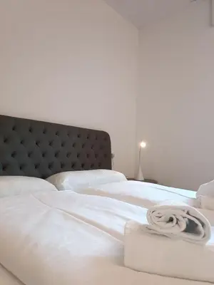a white bed with a white blanket on it at Apartment Teatro in Bolzano