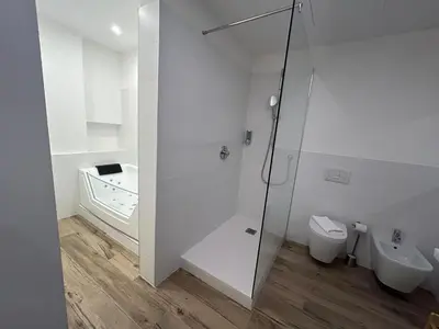 a white bathroom with a toilet and a shower at Apartment Teatro in Bolzano