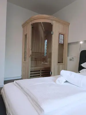 a bedroom with a wooden cabinet with a white bed at Apartment Teatro in Bolzano