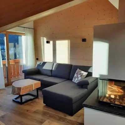a living room with a couch and a fireplace at Appartamento l’ Aier - Arabba - Dolomiti in Livinallongo del Col di Lana