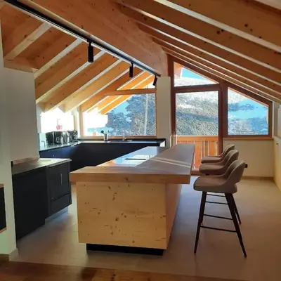a kitchen with a large wooden island in a house at Appartamento l’ Aier - Arabba - Dolomiti in Livinallongo del Col di Lana