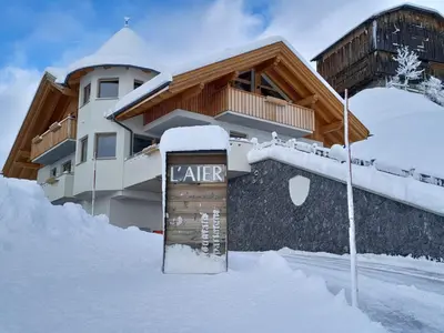 a building in the snow with a sign in front of it at Appartamento l’ Aier - Arabba - Dolomiti in Livinallongo del Col di Lana