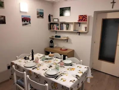 a kitchen with a table with chairs and a table cloth at App. Valentina in Segonzano