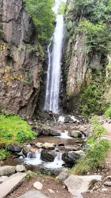 a waterfall on the side of a rocky mountain at App. Valentina in Segonzano