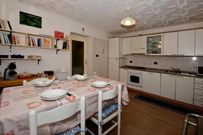 a kitchen with a table and a dining room at App. Valentina in Segonzano
