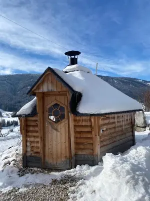 a small wooden cabin with snow on the roof at Mittersteinerhof in Villabassa