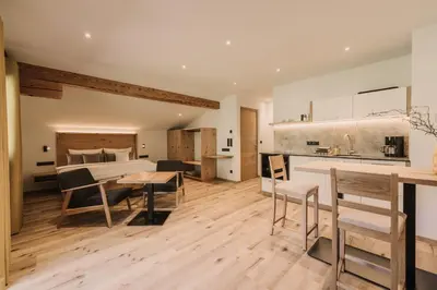 a kitchen and living room with a table and chairs at Birkhof in Lana