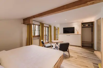 a bedroom with a bed and a table and chairs at Birkhof in Lana