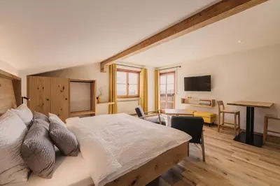 a bedroom with a bed and a living room with a desk at Birkhof in Lana