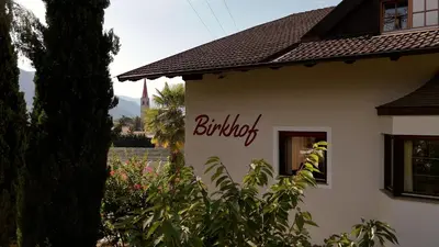 a building with a sign on the side of it at Birkhof in Lana