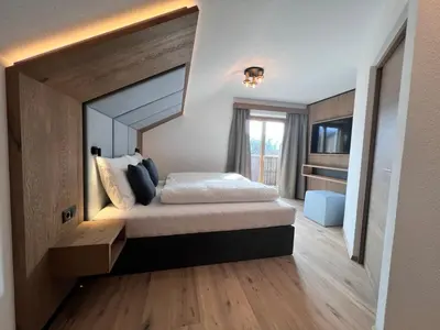 a bedroom with a large bed in a room at Adlhof Apartments in Brunico