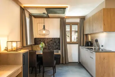 a kitchen with a table and a dining room at Adlhof Apartments in Brunico