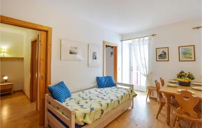 a bedroom with a bed with blue pillows and a table at Amazing Apartment In Località Carbonin in Carbonin