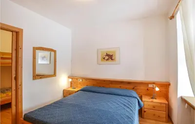 a bedroom with a blue bed and a mirror at Amazing Apartment In Località Carbonin in Carbonin