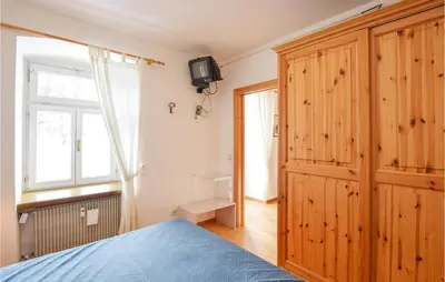 a bedroom with a bed and a wooden cabinet at Amazing Apartment In Località Carbonin in Carbonin