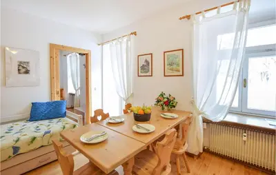 a dining room with a wooden table and a couch at Amazing Apartment In Località Carbonin in Carbonin