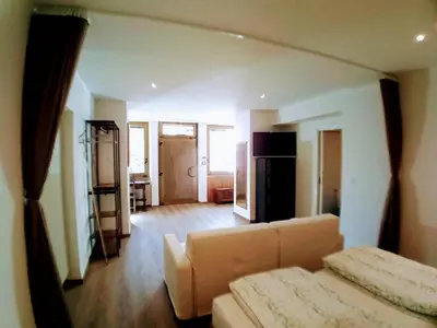 a living room with a couch and a kitchen at Apartment Römerbrücke - Ponte Romano in Merano