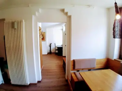 a room with a hallway with a table and a chair at Apartment Römerbrücke - Ponte Romano in Merano