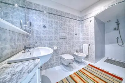 a bathroom with a sink and a toilet and a shower at Apartment Römerbrücke - Ponte Romano in Merano