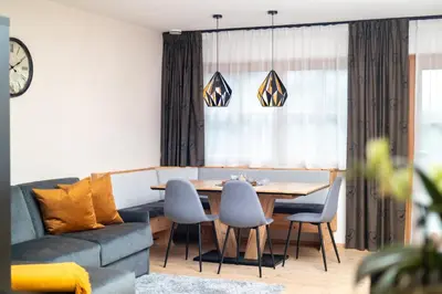 a living room with a couch and a table and chairs at Apartment AEREUS Krumas-Living - Kronplatz in San Lorenzo di Sebato