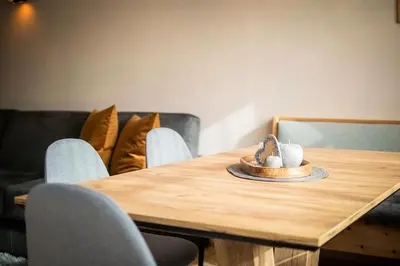a wooden table with chairs and a hat on it at Apartment AEREUS Krumas-Living - Kronplatz in San Lorenzo di Sebato