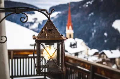 a lantern hanging on a balcony with a view of a town at Apartment AEREUS Krumas-Living - Kronplatz in San Lorenzo di Sebato