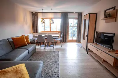 a living room with a couch and a table at Apartment AEREUS Krumas-Living - Kronplatz in San Lorenzo di Sebato