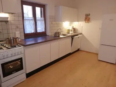 a kitchen with white cabinets and a stove top oven at Gosthof Kastelruth in Castelrotto