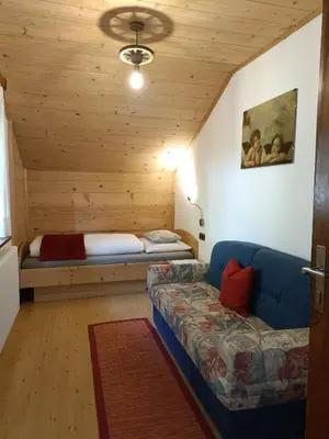 a living room with a couch and a bed at Gosthof Kastelruth in Castelrotto